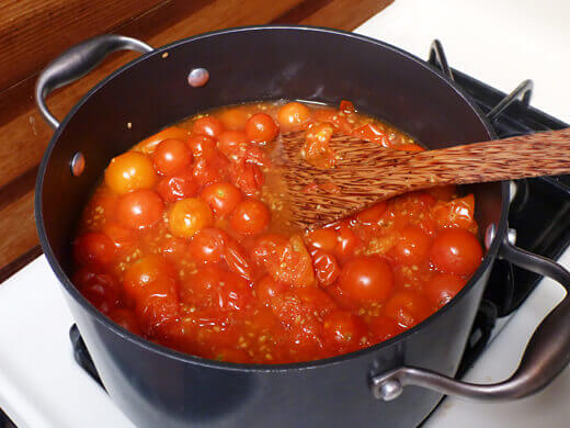 Stir tomatoes as they simmer in their own juices
