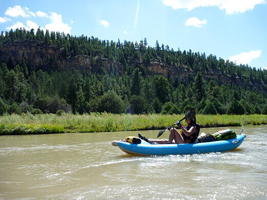 Paddling through the evergreen-filled Chama Canyon