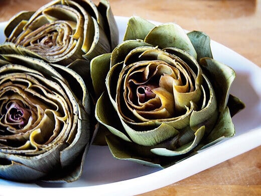 Pry artichoke leaves apart to prepare for stuffing