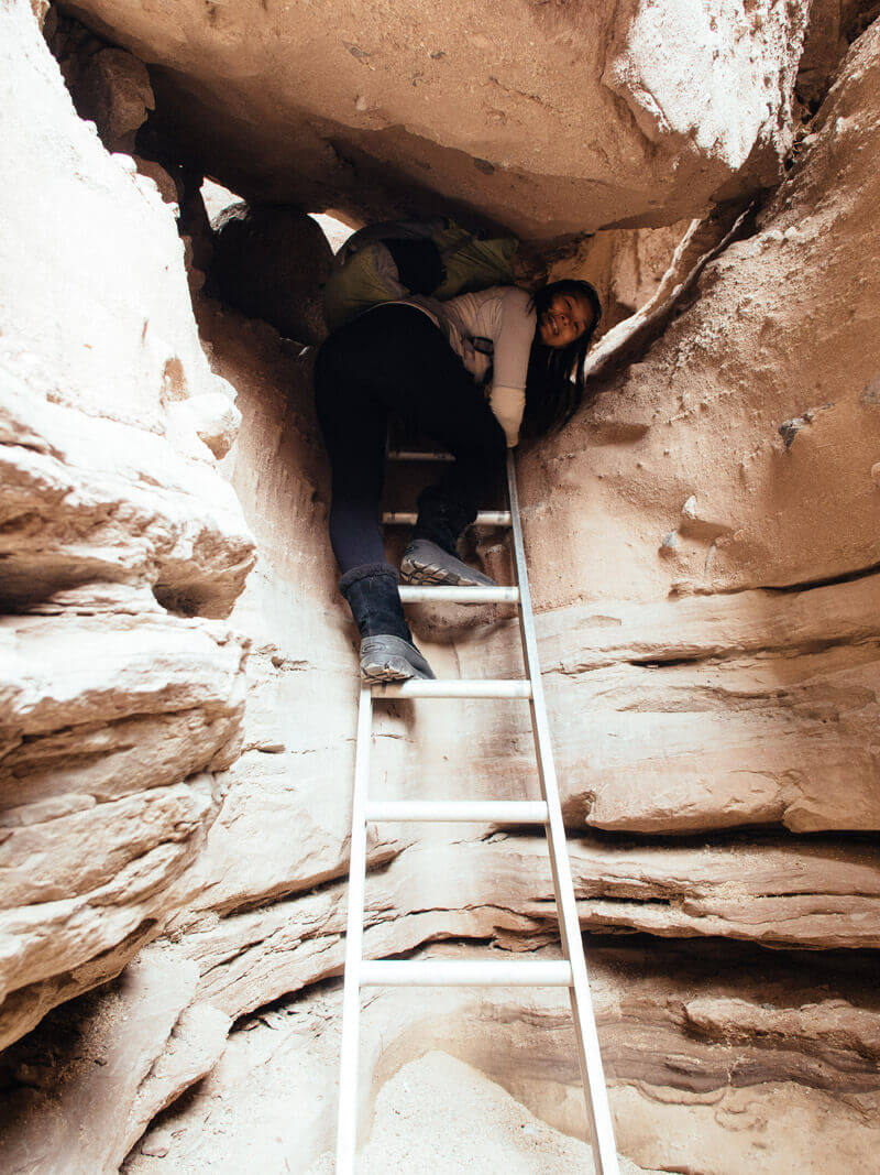 Climbing a ladder into the slot canyon