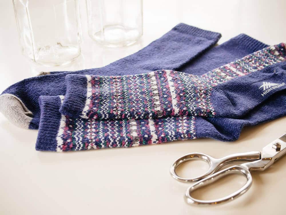 Gather socks, scissors, and needle and thread