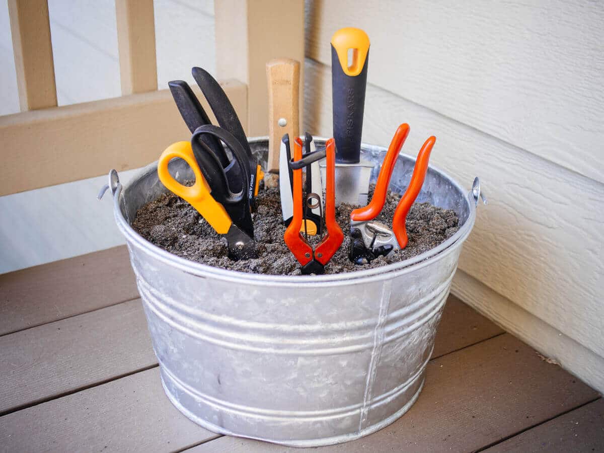Store gardening tools in a bucket filled with sand and oil to prevent rust and keep blades sharp