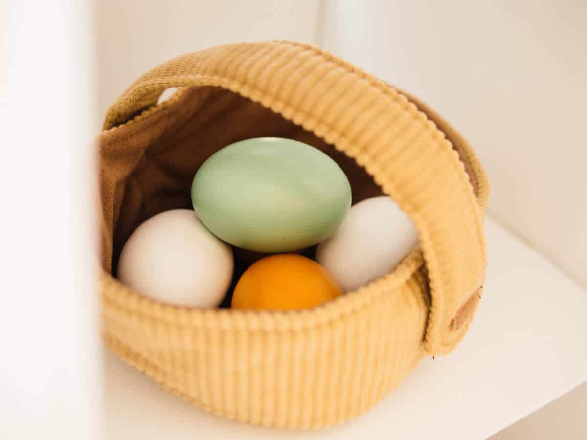 Multi-colored wooden eggs in basket