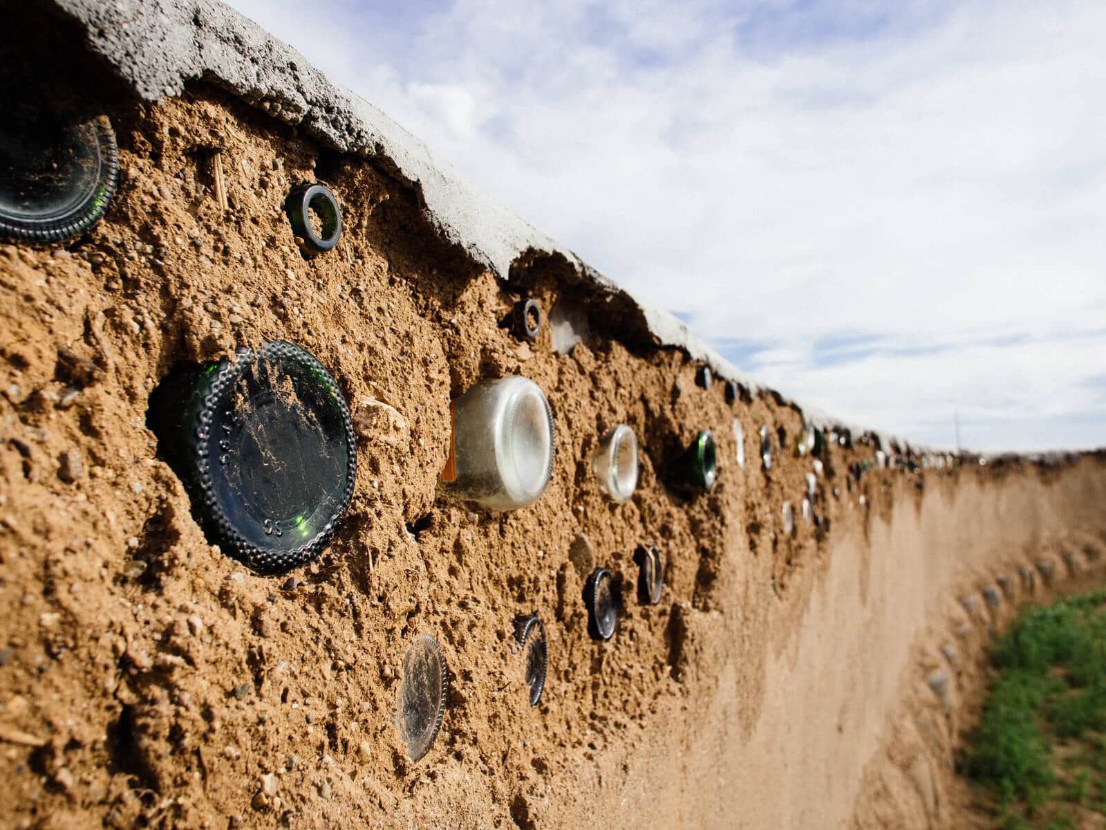 Adobe mud wall made from recycled glass bottles and aluminum cans