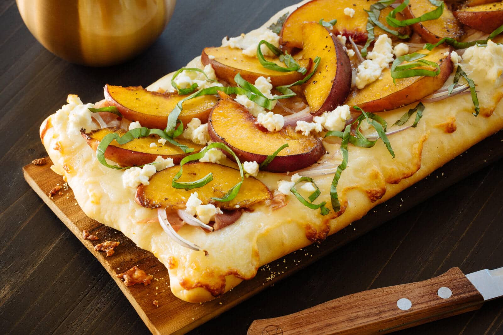 Plank-grilled peach and prosciutto pizza