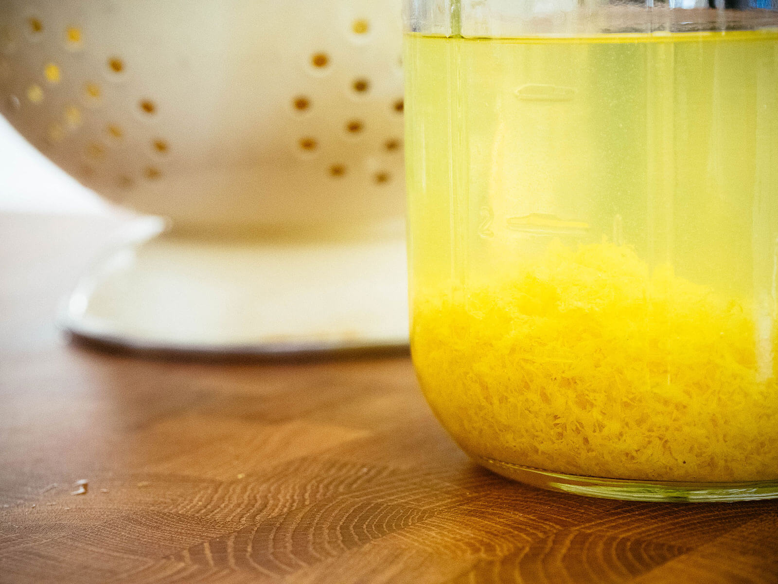 Close-up of lemon zest steeping in a jar of grain alcohol