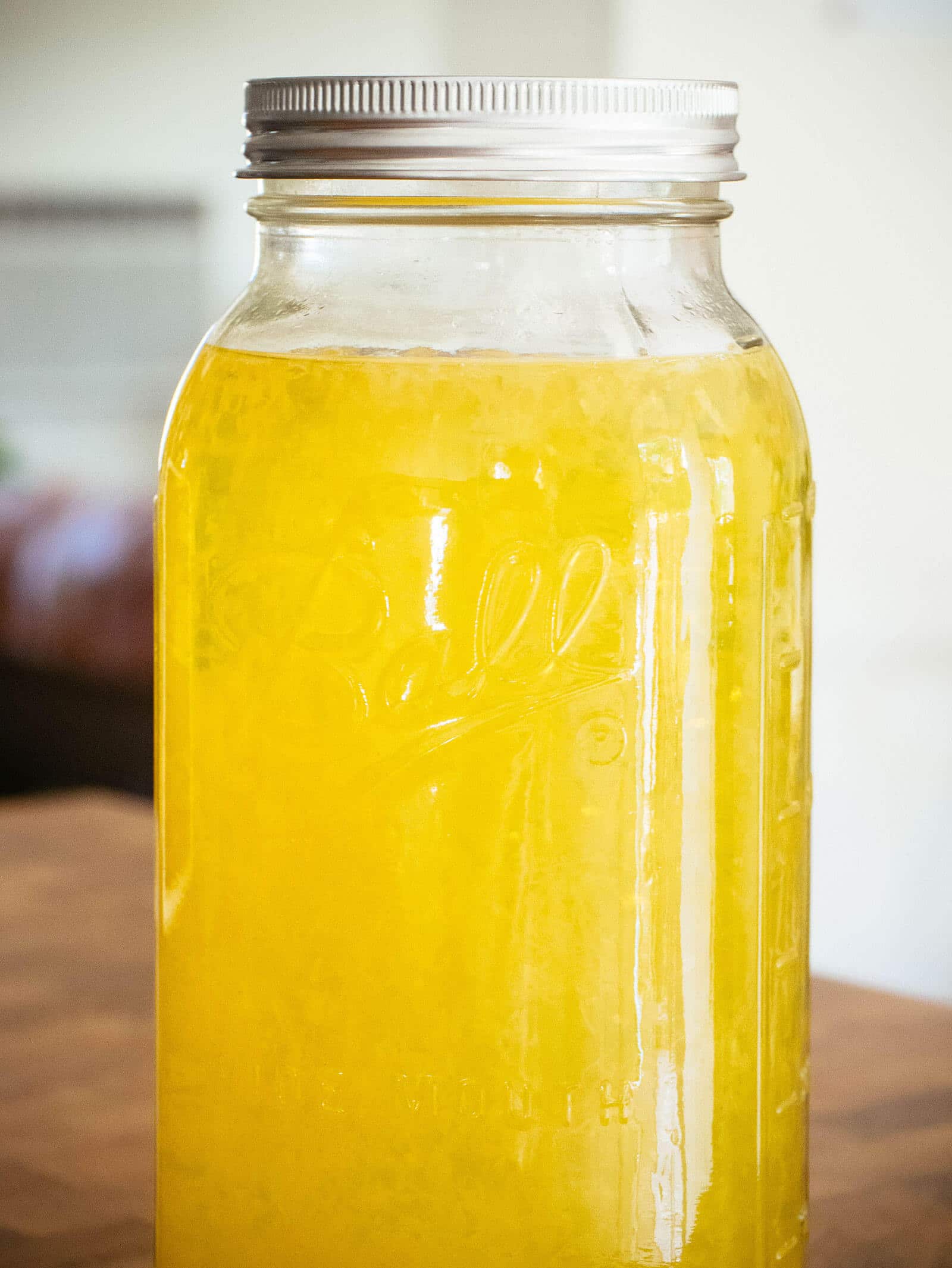 Batch of unstrained limoncello infusing and aging in a jar