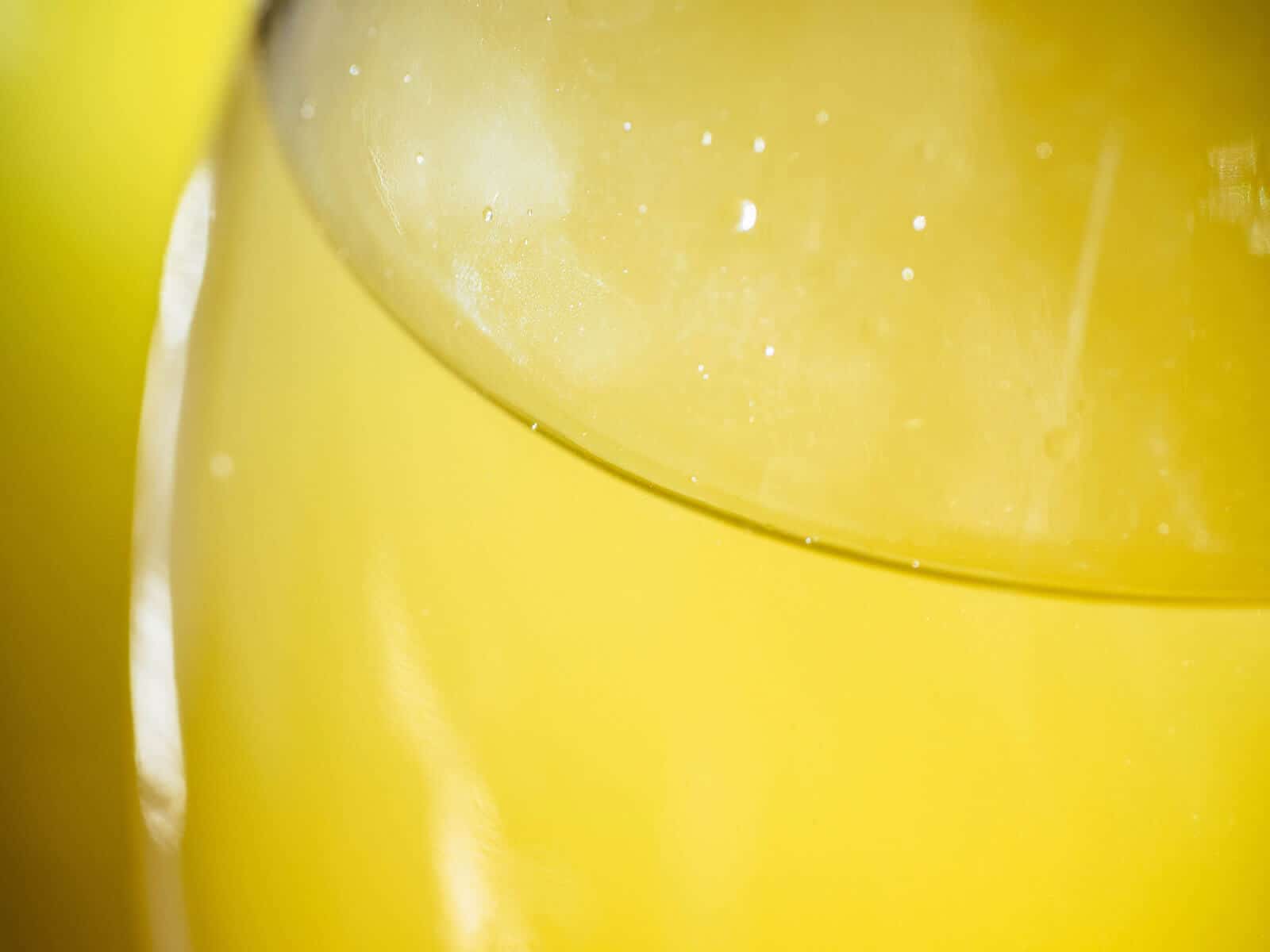 Close-up of "lemon collar" (ring of lemon oil) in limoncello liqueur