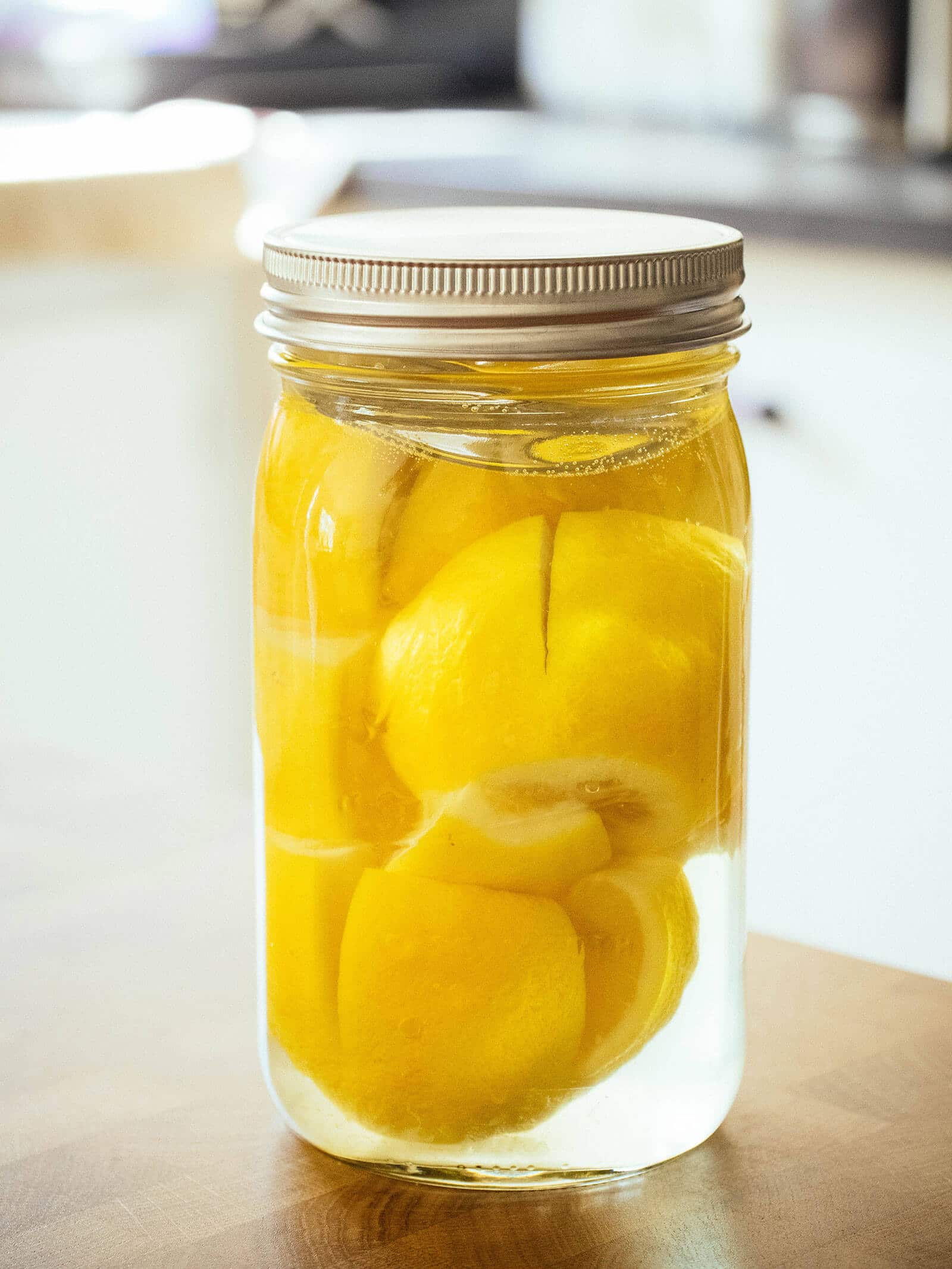 Jar full of lemons being preserved in brine