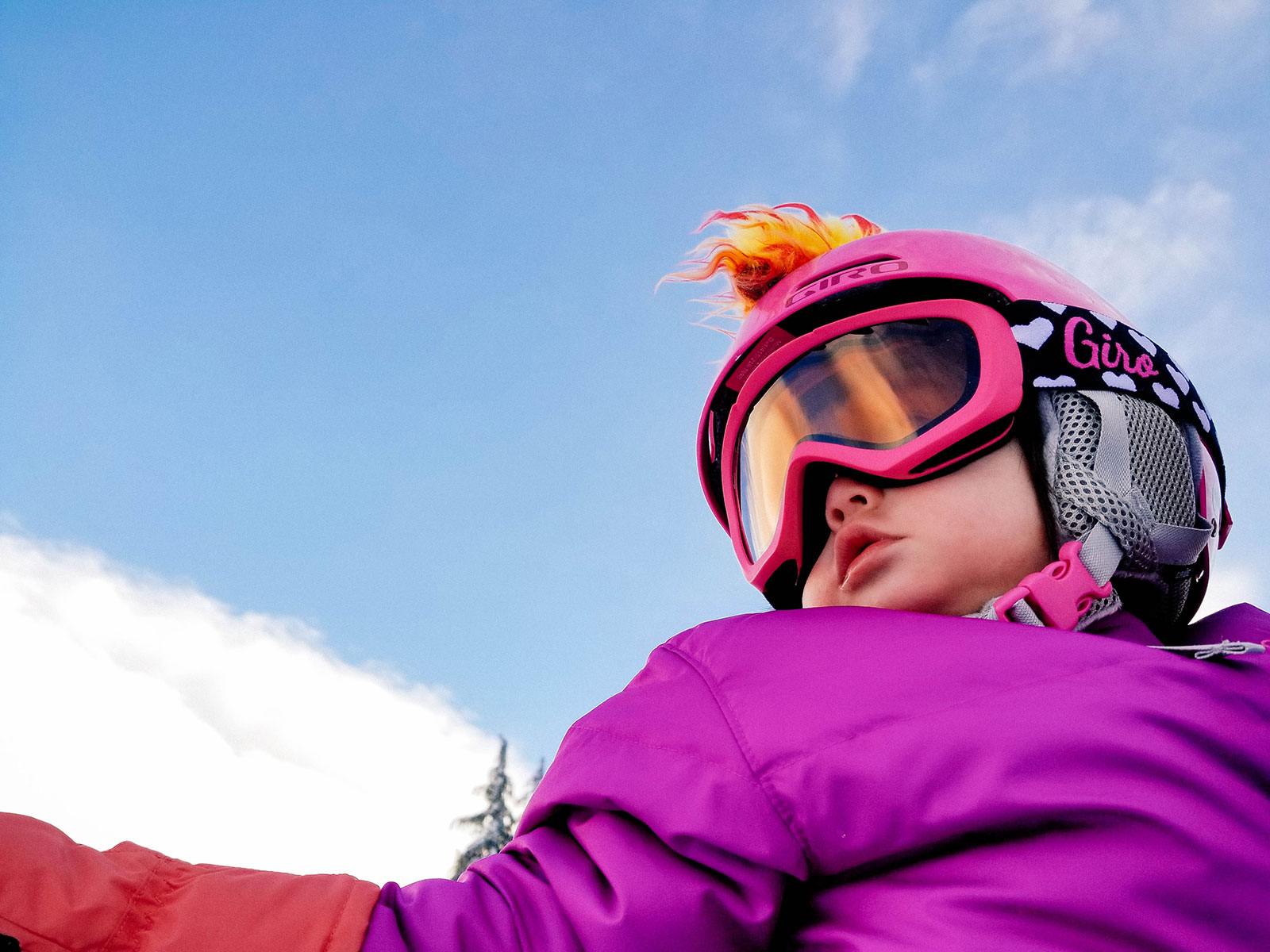 Toddler wearing a snowboard helmet with matching goggles