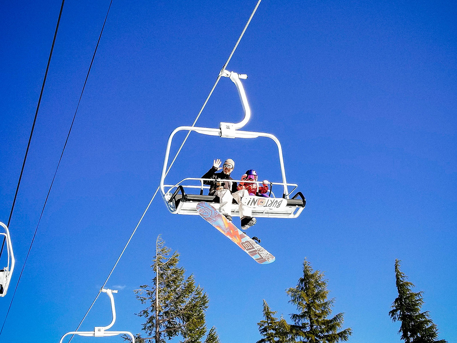 Dad and toddler riding on a chairlift at a ski resort