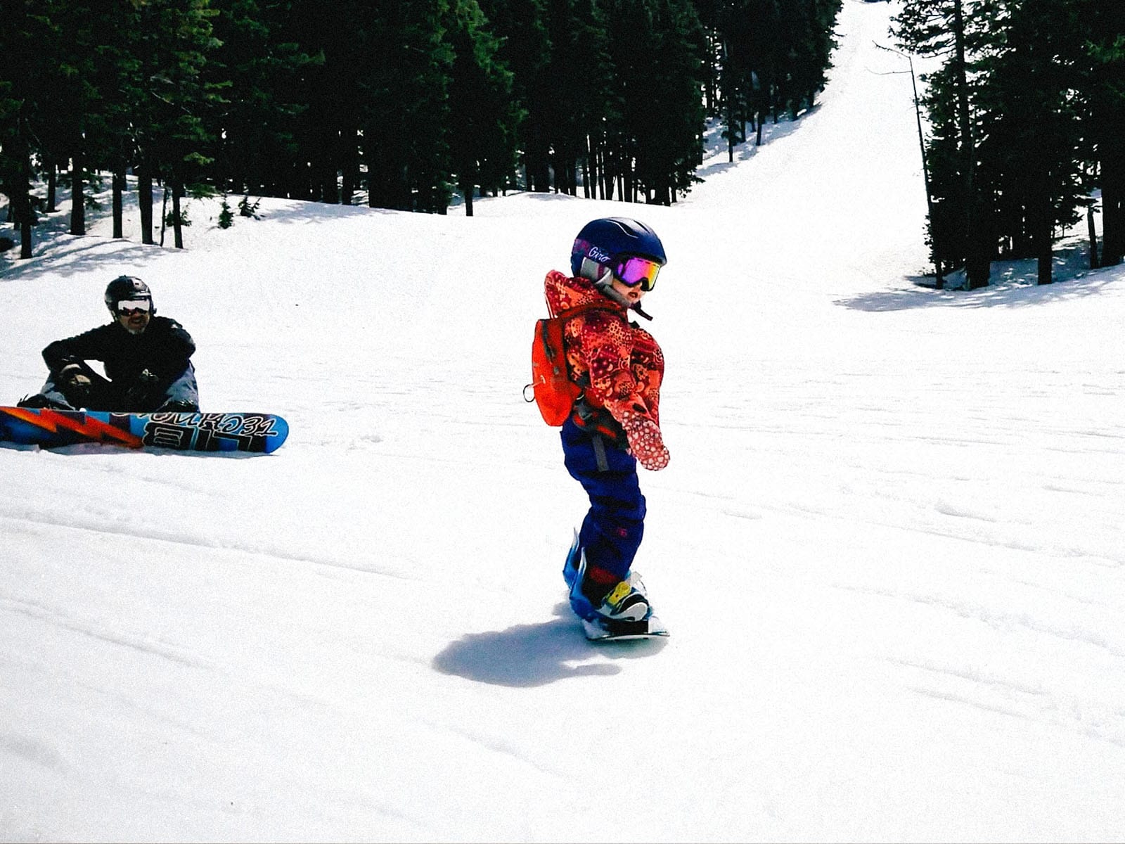 A 3-year-old learning how to snowboard independently
