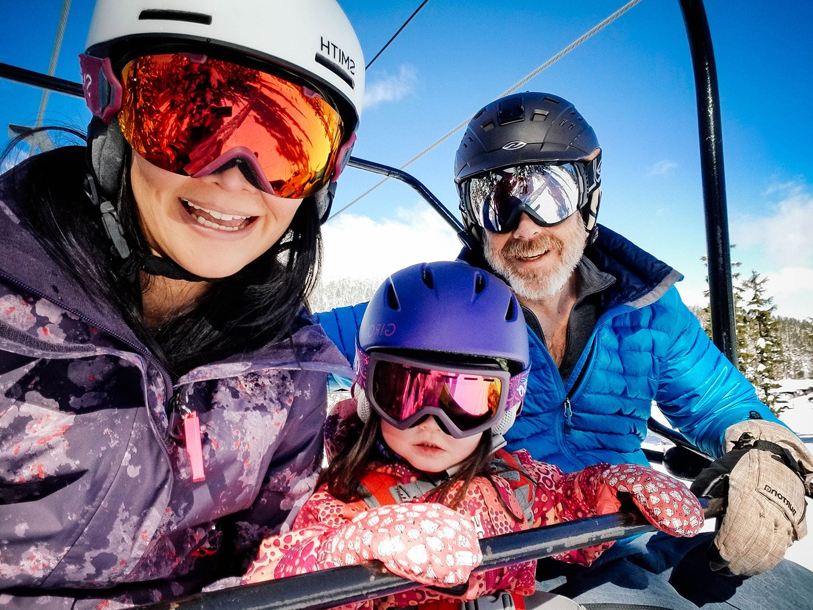 Mom and Dad riding a chairlift with a toddler