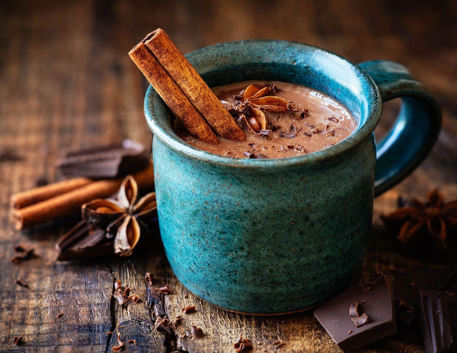 Blue mug of hot chocolate with a cinnamon stick