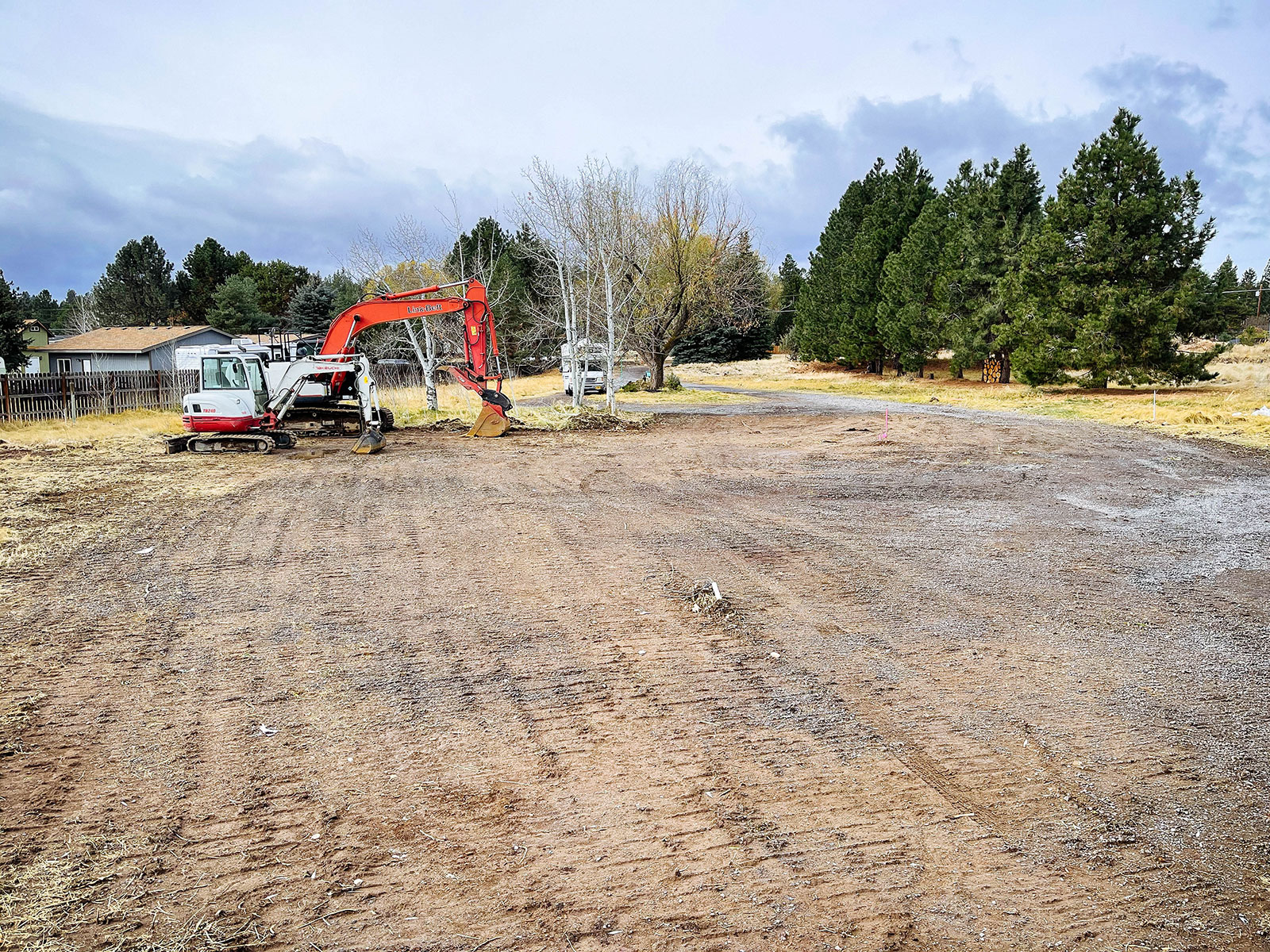 Smooth and graded land after demolition, with excavators parked in the background