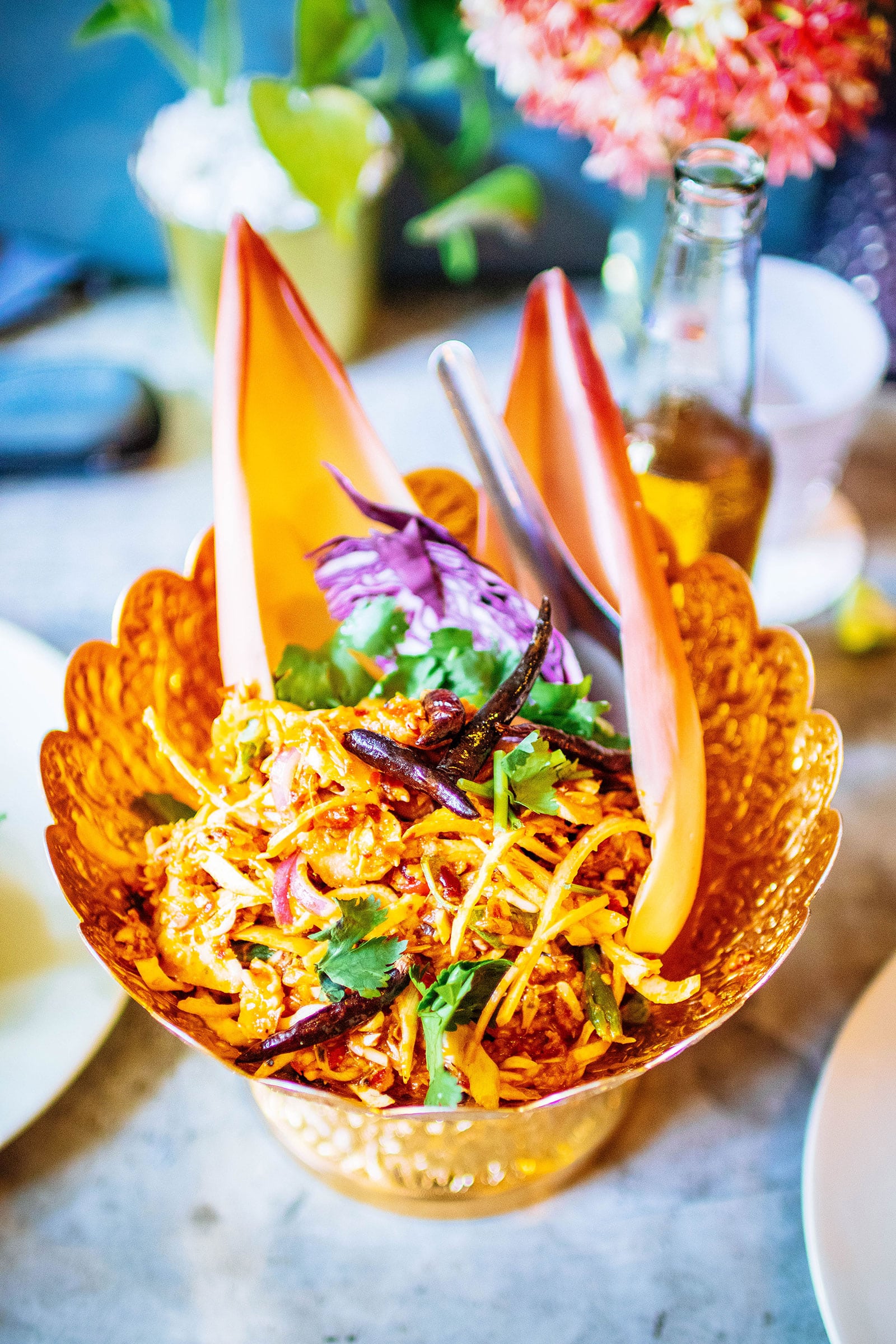 Thai banana blossom salad in a gold bowl with banana bracts used as a garnish