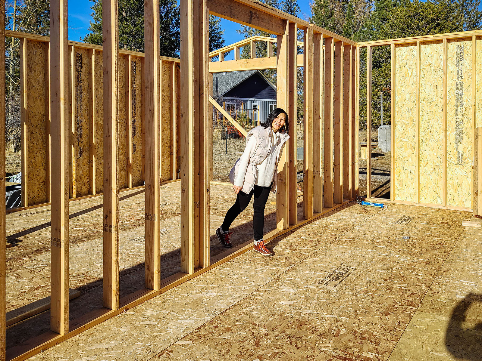 Woman walking through a framed doorway in a house under construction