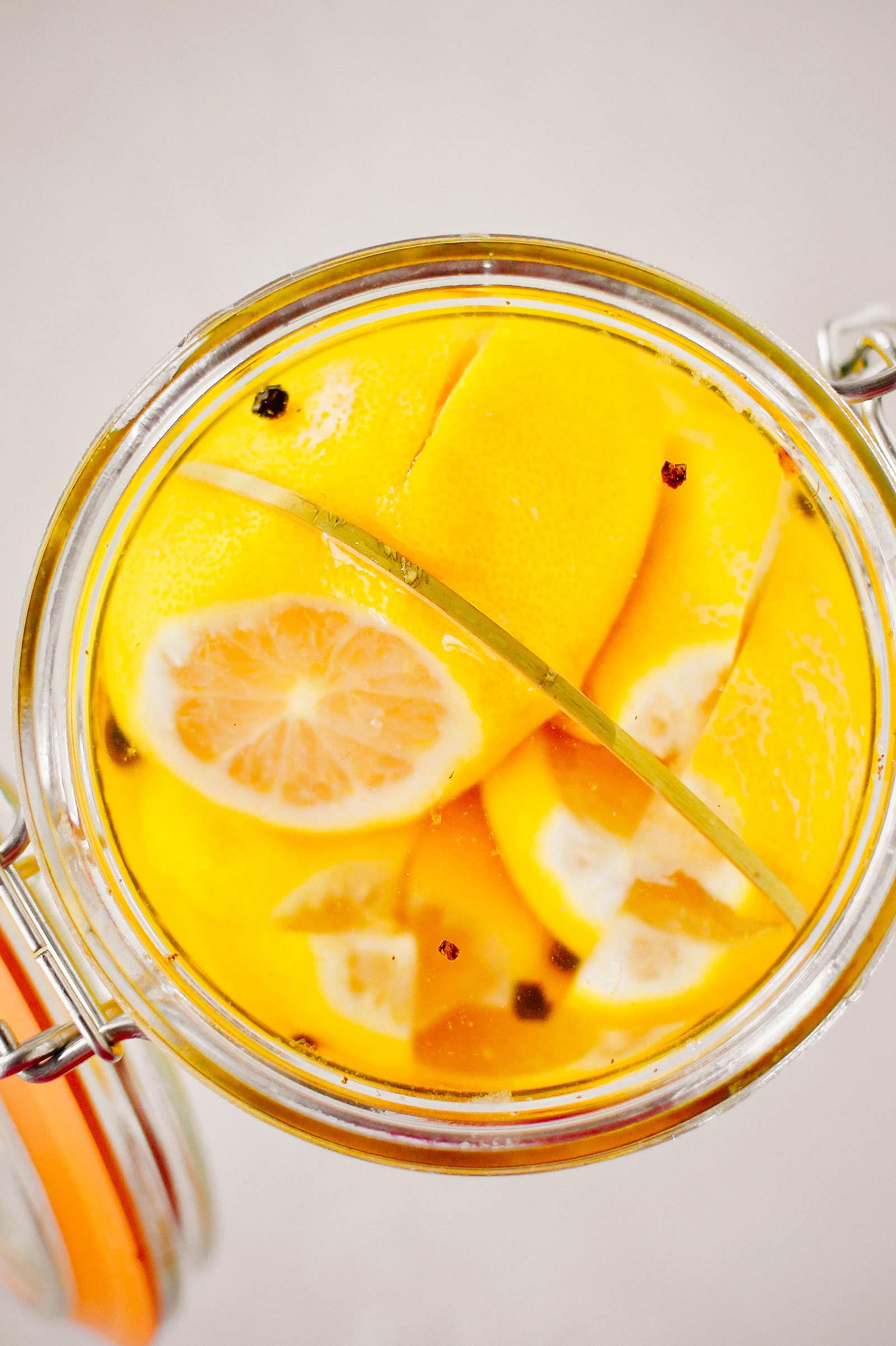 Close-up view of a toothpick stretched across inside the mouth of a jar to hold lemons down