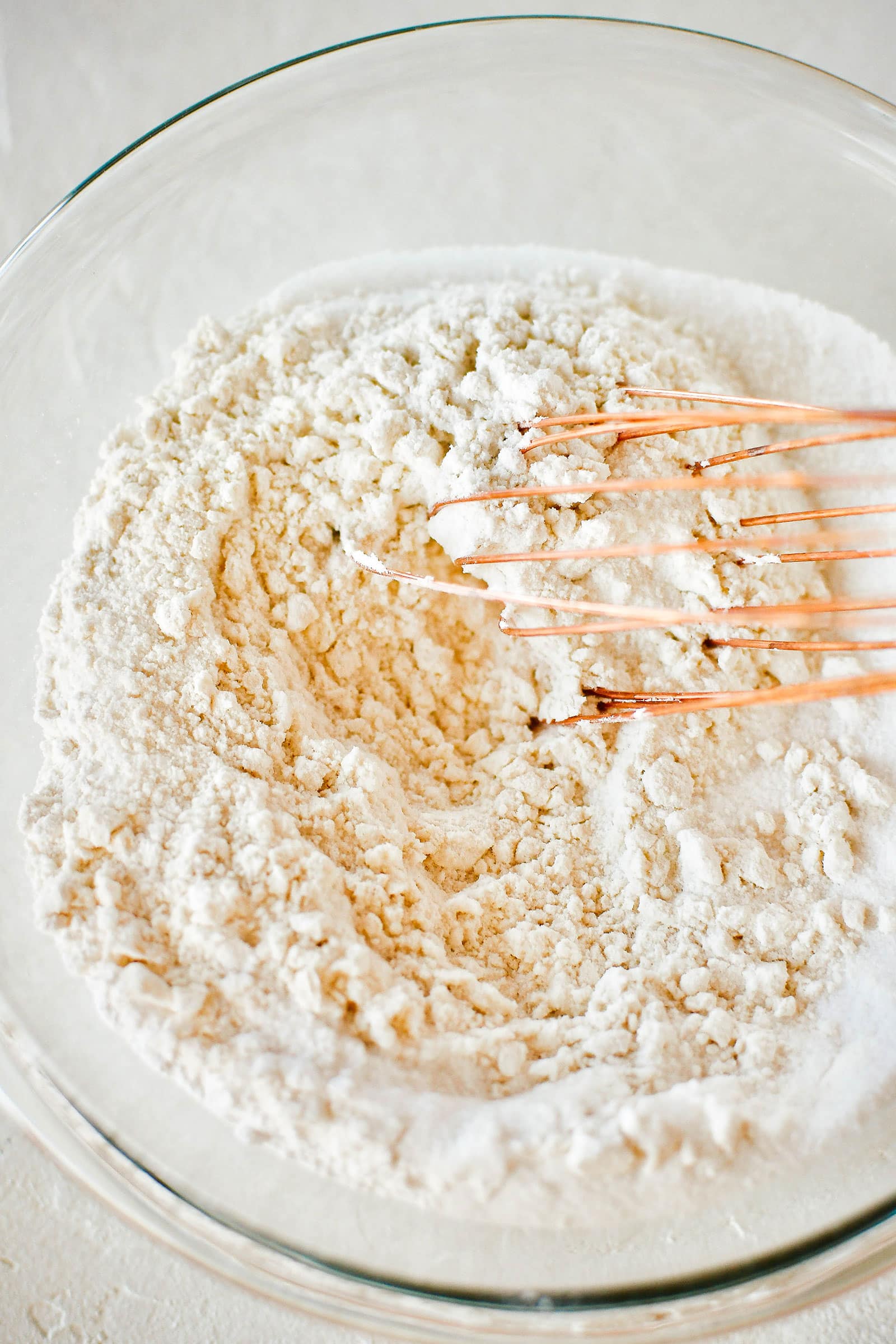 A whisk mixing all the dry ingredients together in a bowl