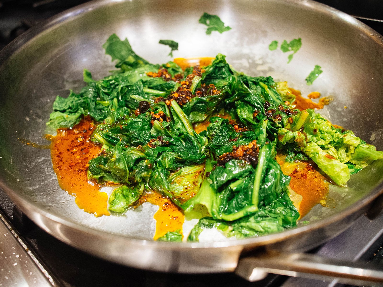 Lettuce sauteed with chili crisp in a pan