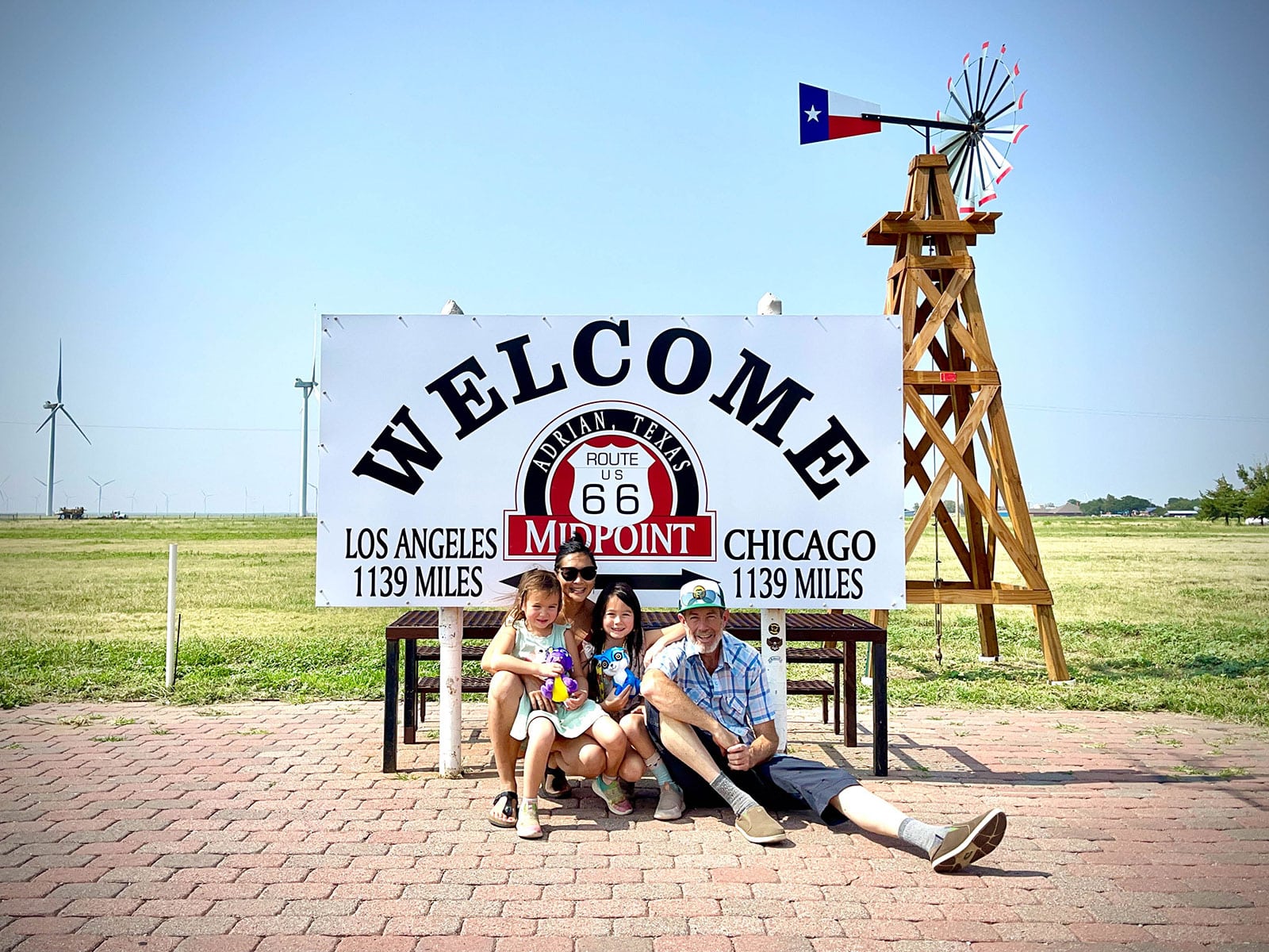 Family posing in front of the selfie sign at the Route 66 midpoint in Adrian, Texas