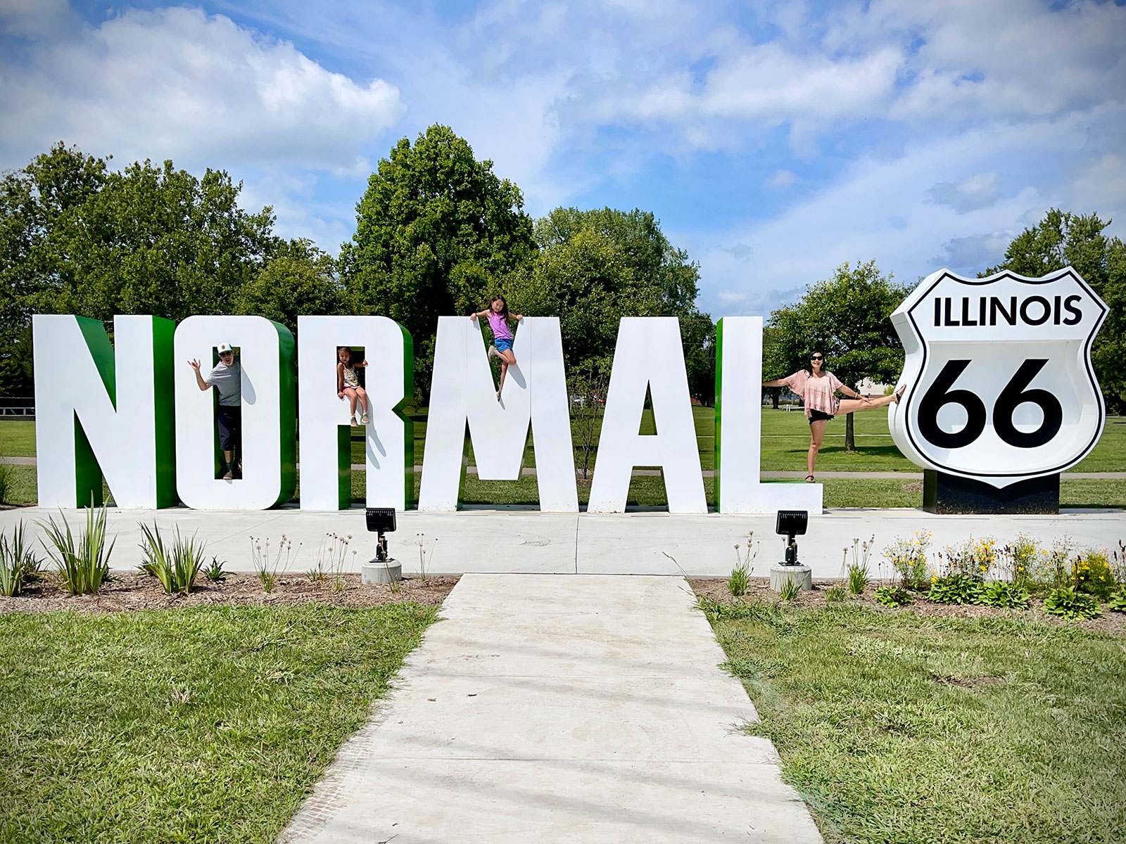Family posing on the life-sized Route 66 sign in Bloomington, Illinois